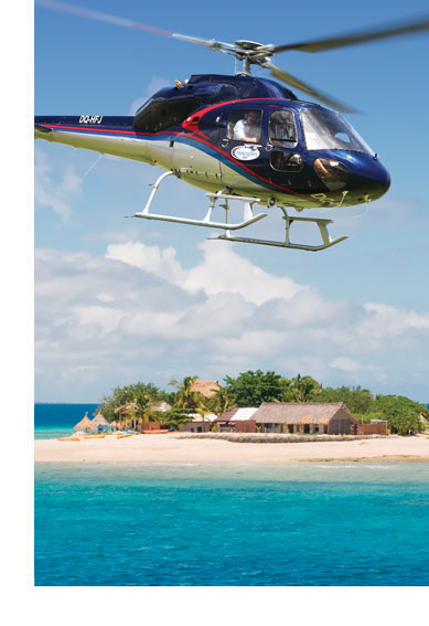 Pacific Island Air helicopter flying over a beach resort island in Fiji