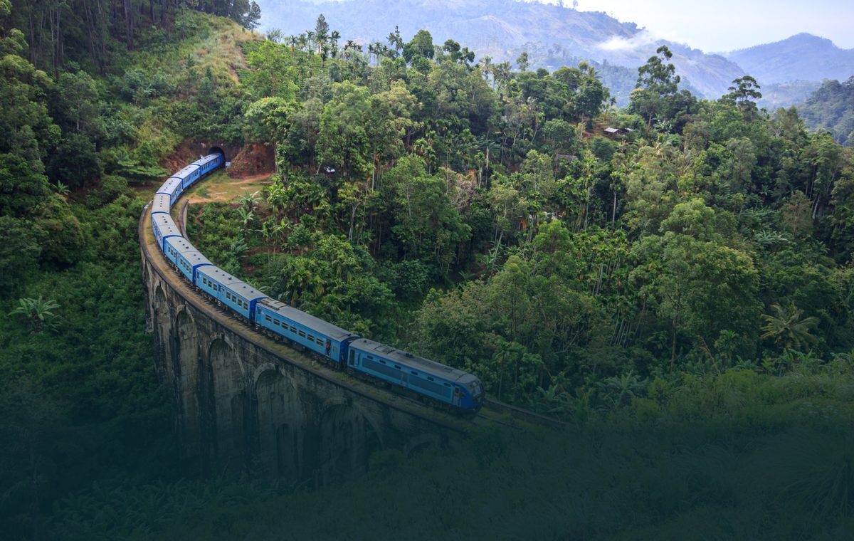 Blue train crossing the Nine Arch Bridge through the hills of Ella, Sri Lanka